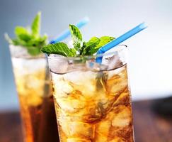 iced tea with blue straw and mint garnish photo