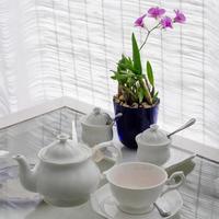 Ceramic utensils on table with flower decoration photo