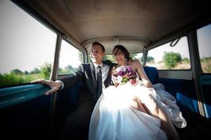 recién casados en coche de boda foto