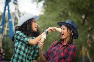two beautiful girls in cowboy hats eating ice cream photo
