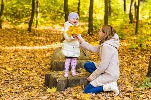 happy family mother and  little daughter playing on autumn walk photo