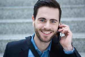 Smiling young man calling by mobile phone