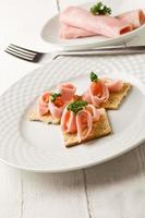 Crackers canapes with ham and parsley photo