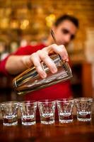 Close-up of Barman pouring alcoholic drink and cocktails photo