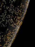 Macro of side of glass showing champagne bubbles