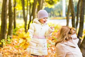 happy family mother and  little daughter playing on autumn walk photo