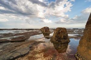 Brown rock formation surrounded with water photo