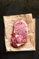 Raw ribeye steak with salt and pepper photo