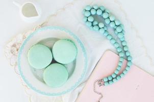 Mint macaroon and teal beads on light background