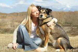 Mujer abrazando al perro pastor alemán fuera