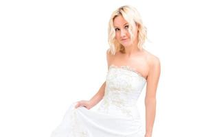 charming blonde in a white wedding dress in the studio photo