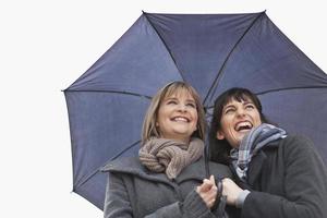 Smiling women under umbrella