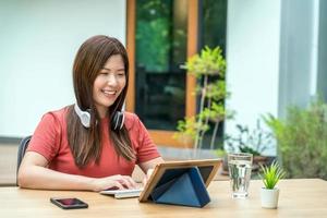 Empresaria asiática con tableta de tecnología al aire libre foto
