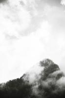 Grayscale of mountain peak and clouds photo