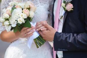 el novio sostiene la mano de su novia foto