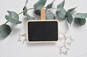 Mock up of eucalyptus branch, decor of stars and wooden board photo