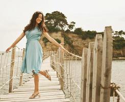 Young happy woman on the bridge near sea