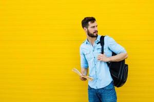 handsome man with backpack on yellow