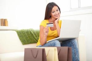 Confident woman using a credit card for shopping photo