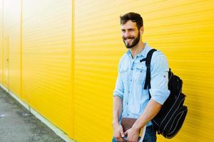 handsome man with backpack on yellow