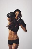 A female in black exercising with boxing gloves photo