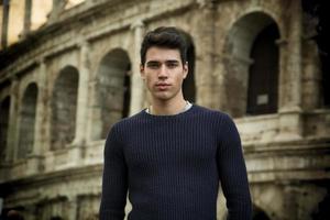 Handsome young man in Rome standing, front of the Colosseum photo