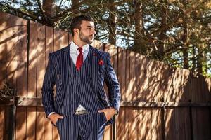 Man against wooden fence In stylish suit. photo