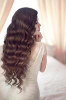 Beautiful brunette bride with long healthy wavy hair styling photo