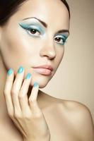 Beautiful young woman with bright make-up and manicure