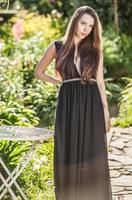Woman in luxury black dress posing in summer garden. photo