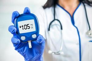 Closeup composition of woman doctor holding glucometer.