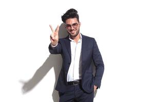 Smiling business man showing the victory sign photo