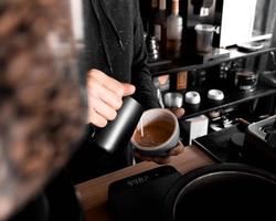 Barista pouring cream in cup photo