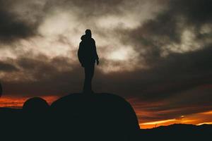 Man standing on rock during golden hour