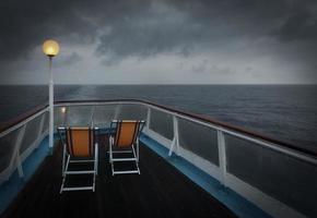 Two folding chairs on a boat at sea  photo