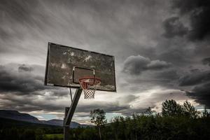 Wooden basketball hoop under dark clouds  photo