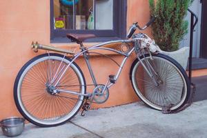 White bicycle next to orange building photo