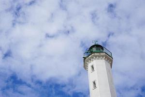 Lighthouse with cloudy blue sky photo