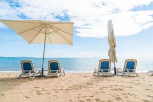 al aire libre con sombrilla y silla en la hermosa playa tropical y el mar