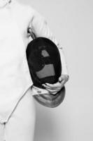 Close-up of person holding fencing mask photo