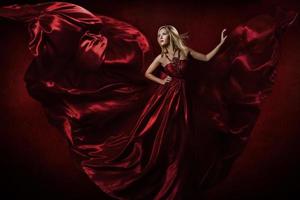 Woman in red dress dancing with flying fabric