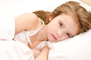 Sick little girl lying in the bed photo