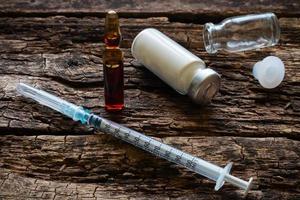 Medical syringe and ampoules on a wooden background photo
