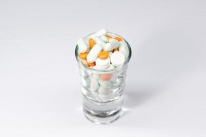 pills and glass on white background photo