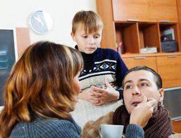 Loving wife and son caring for sick man photo