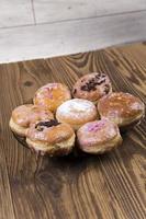 Fresh donuts on wooden table photo