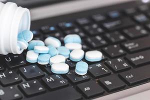 Close up Medicine pills on laptop, hard work concept