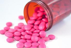 Pink tablet fall from dispensing bottle photo
