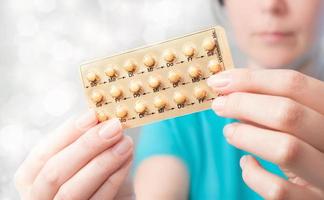 Young woman with birth control pills photo