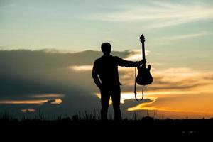 Silhouette of musician with guitar  photo